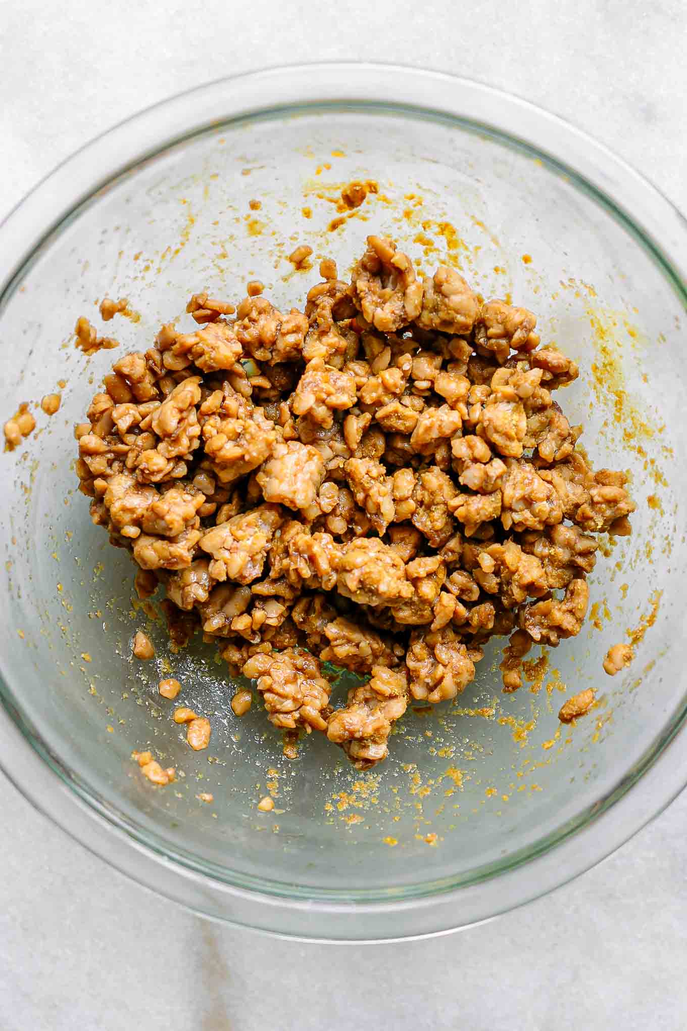 a glass bowl with marinated tempeh