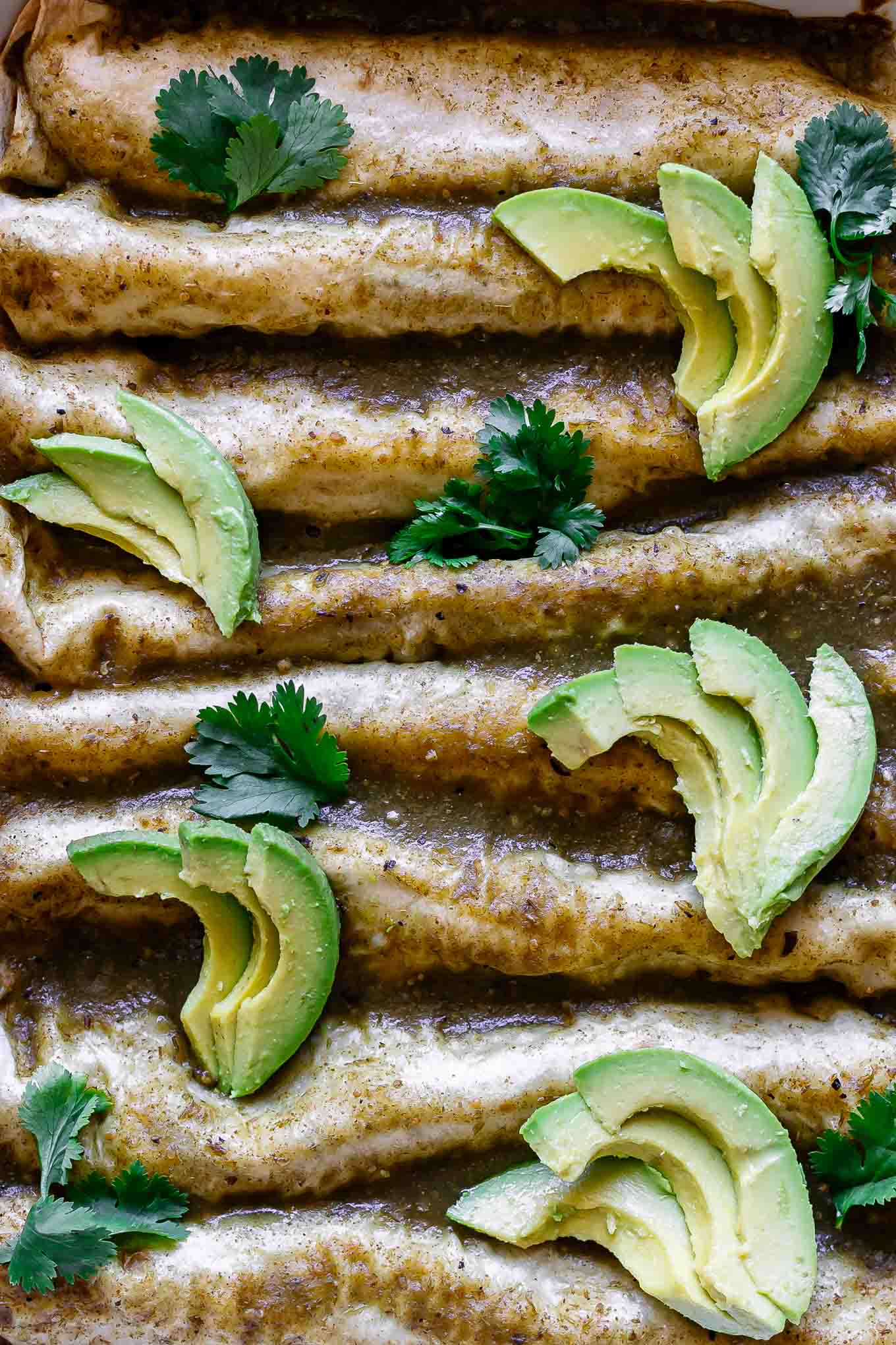 a close up photo of zucchini enchiladas with green enchilada sauce